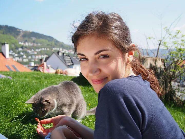 Photo of Martina and a grey cat enjoying the sun on a lawn at Klosteret in central Bergen