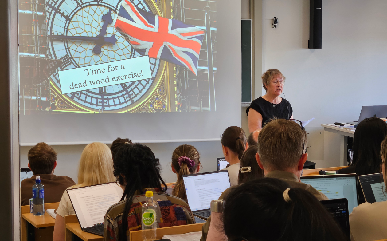 A teacher on the podium in front of a class of students.