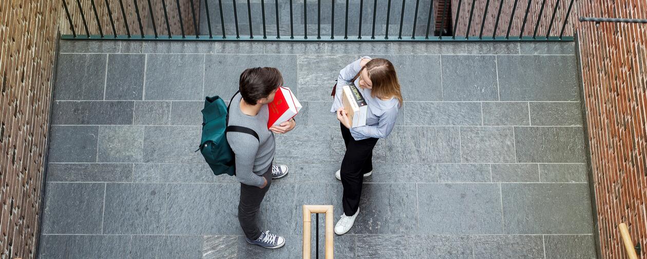 To studenter holder pensumbøker på Jussbygget