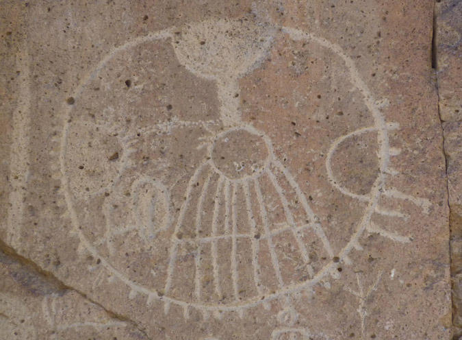 Etching on a rock face of a circle with some outer ticks and some inner markings