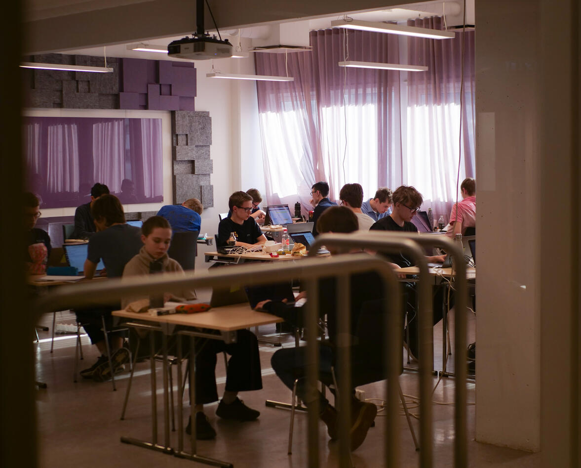 Ungdommer sitter i et klasserom med hver sin laptop
