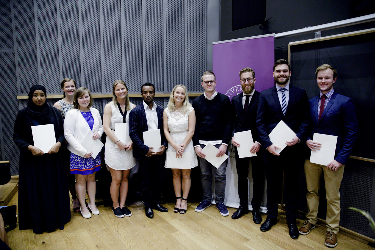 Ti kandidater har mottatt sine vitnemål og mottar applaus foran i auditoriet.