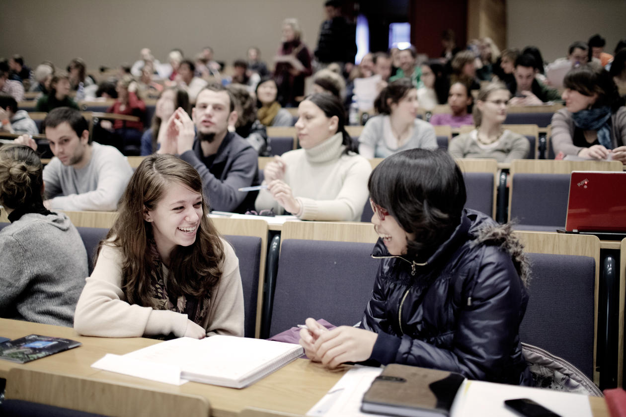 Bilde av studenter som snakker sammen i forelesningssal.