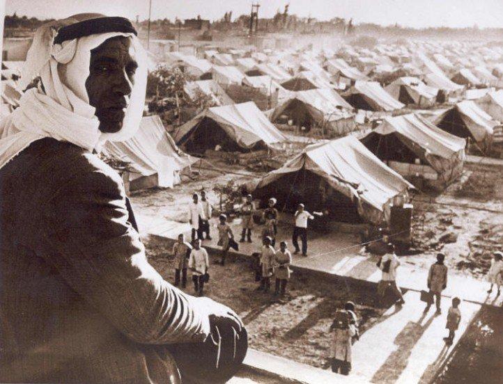 Old photo of man by tents