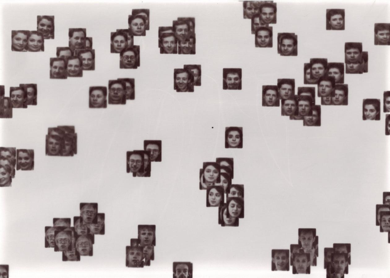 A laptopogram based on a neutral background and populated by scattered squared portraits, all monochromatic, grouped according to similarity. The groupings vary in size, ranging from single faces to overlapping collections of up to twelve.