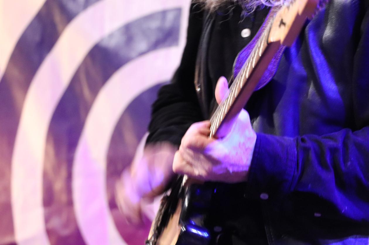 overkroppen til ein person som speler gitar