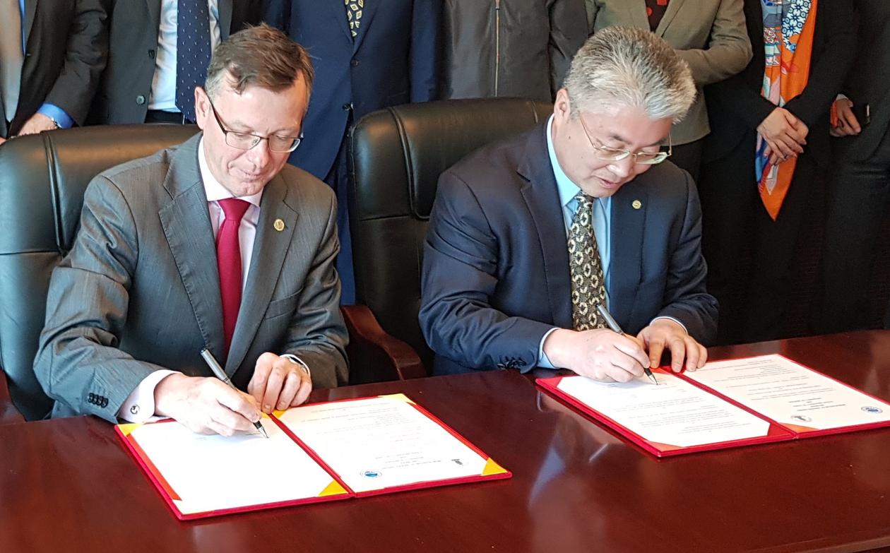 UiB-rektor Dag Rune Olsen og OUC-president Yu Zhigang signerer avtale om samarbeid i Qingdao i april 2018.