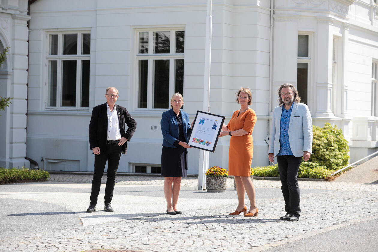 Rector Margareth Hagen is handed a UN certificate from Lise Øvreås of SDG Bergen Ocean for the University of Bergen becoming UNAI SDG14 Hub 2021-2024 with Marine Director Amund Maage (left)  and Edvard Hvidingi of SDG Bergen Science Advice (right).