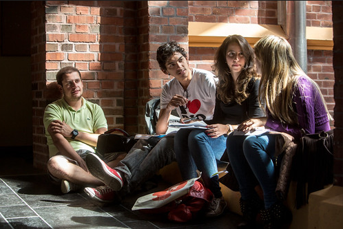 Fire studentar som sitt i ein korridor på UiB