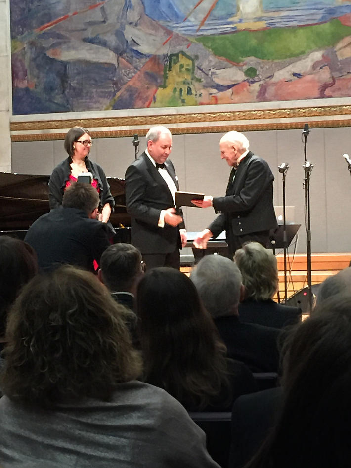 Akslen and Wik receives the grant from Olav Thon,  on stage at the University Aula in Oslo, under the Munch painting The Sun.