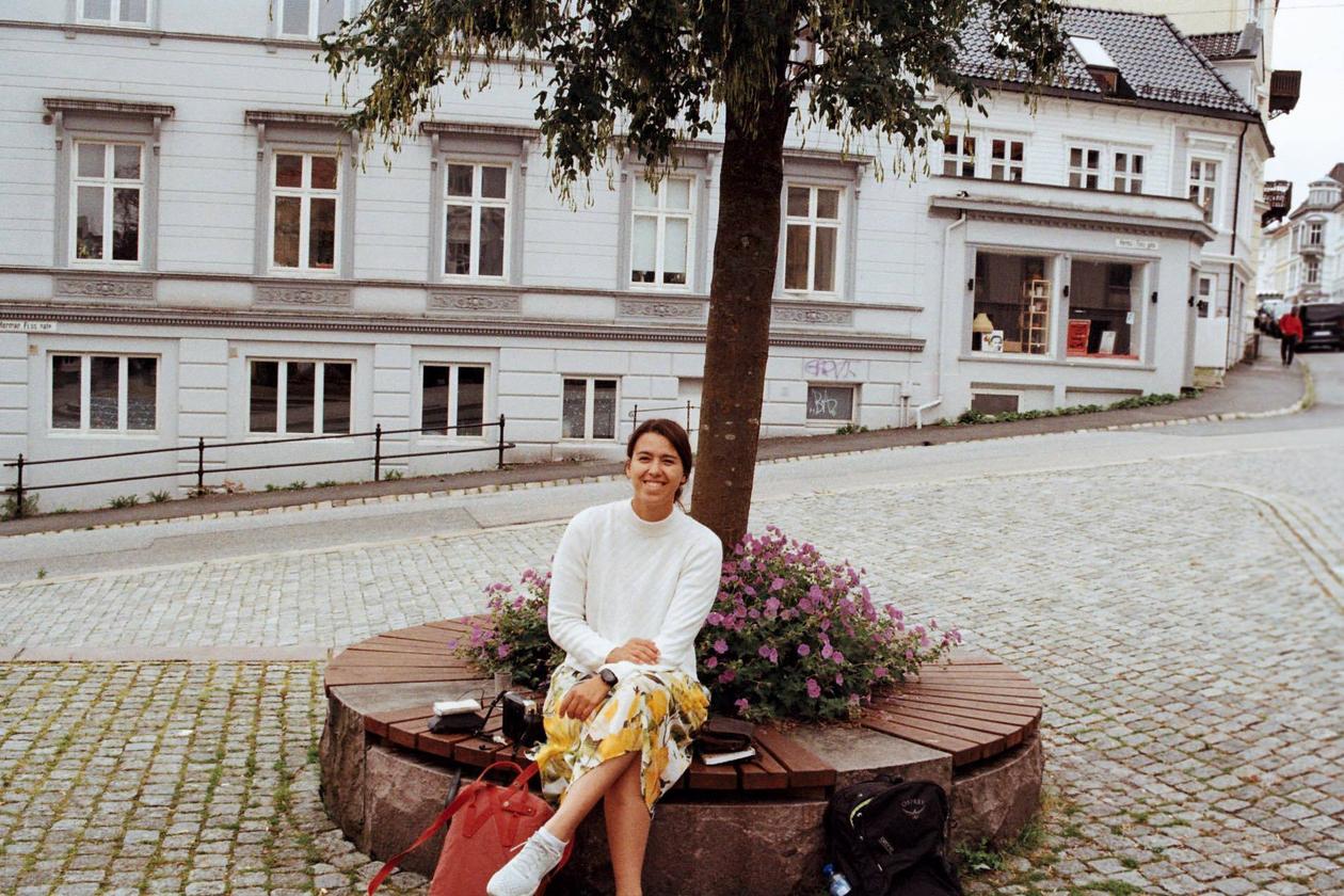 Tina Firing sittende på en benk under et tre i Bergens gater