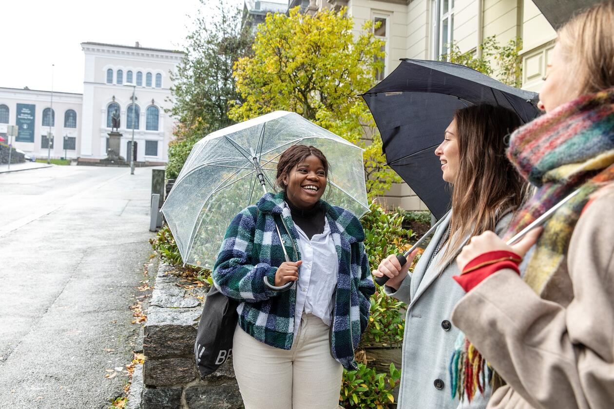 Tre smilende studenter. 