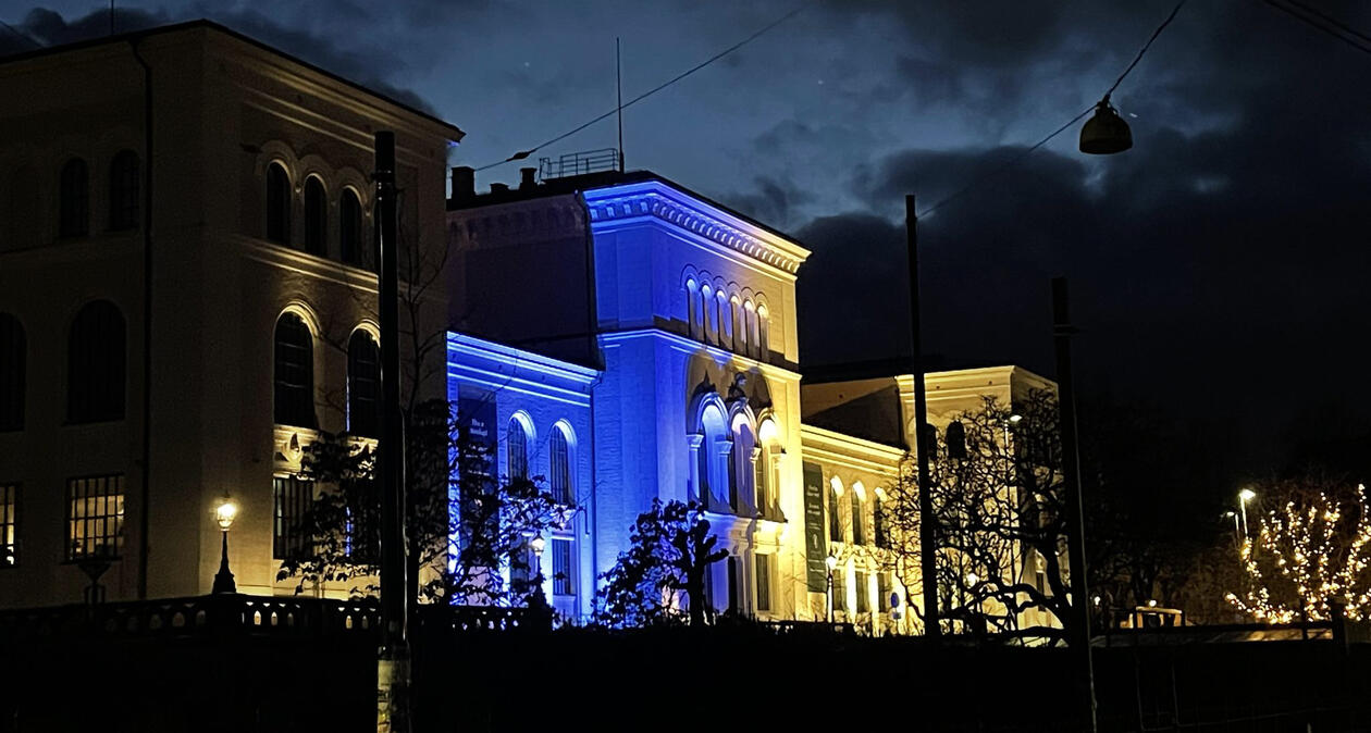 Bilde av Universitetsmuseet lyst opp i blått og gult 