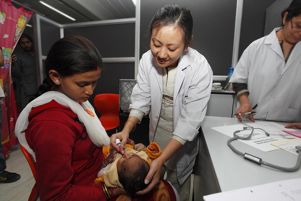 Temsunaro Rongsen-Chandola administering an oral rotavirus vaccine in India