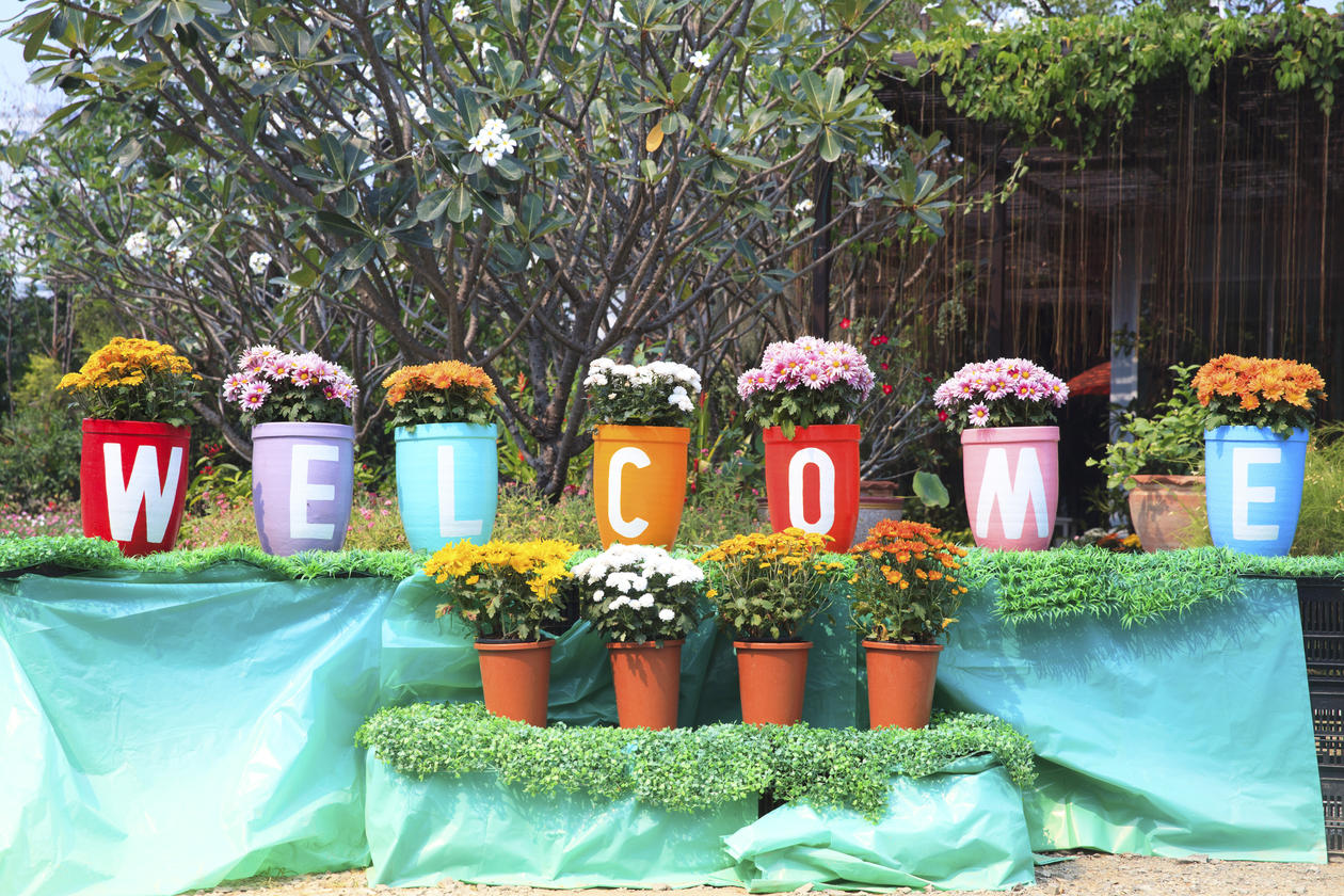 Bildet viser blomsterpotter med bokstaver som danner ordet welcome