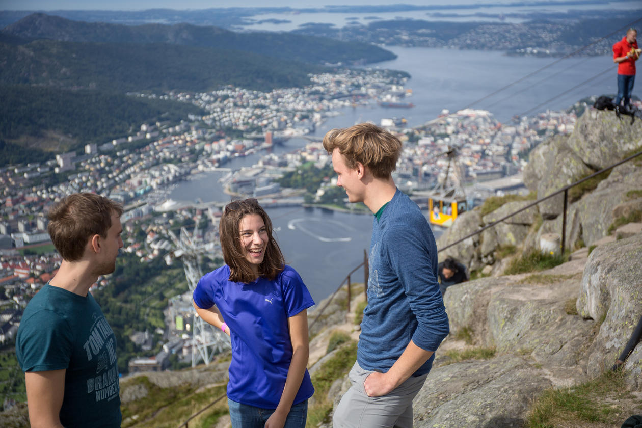 Three students on top of Mount Ulriken with Bergen in the background