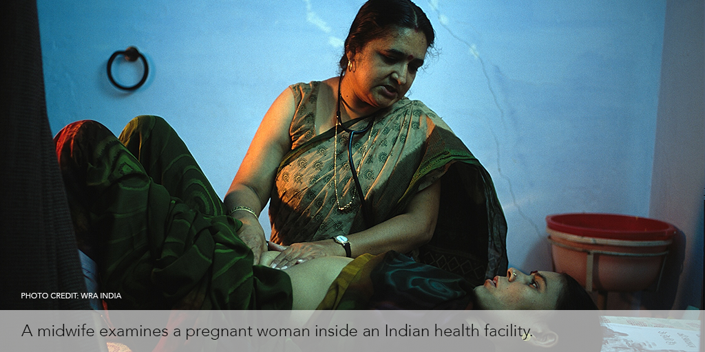 Midwife examines a pregnant woman inside an Indian health facility