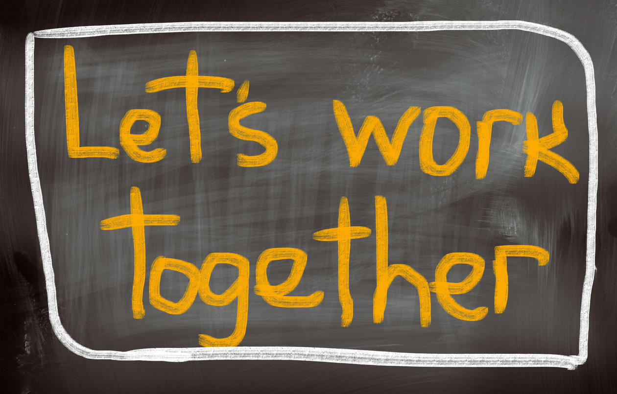 Ordene "let's work together" på en skoletavle