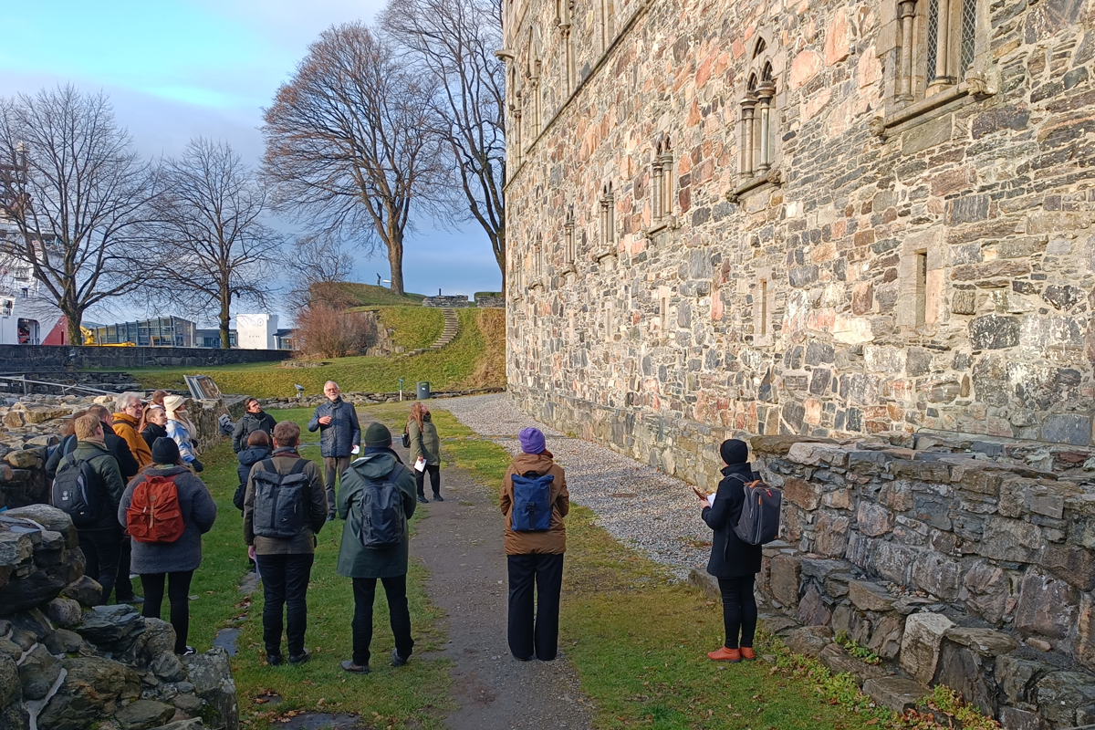 En gruppe mennesker står utenfor Håkonshallen