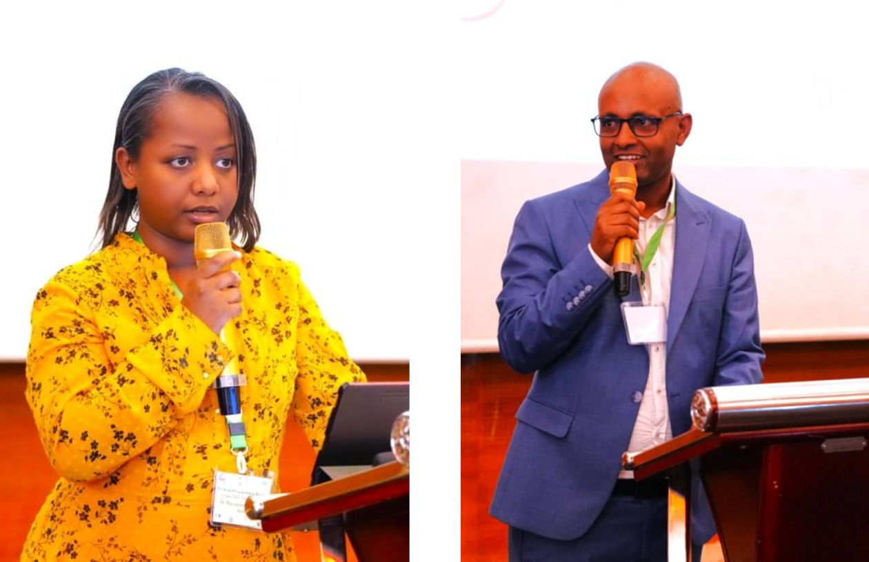 Two speakers holding a microphone