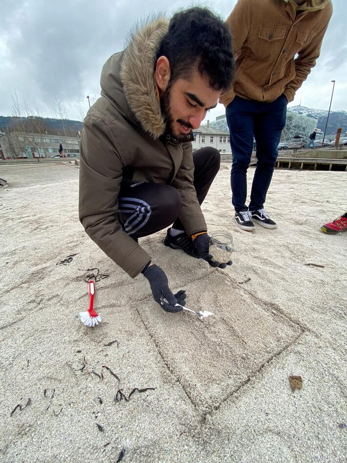 UiB masterstudent Ilyasse Bsaithi tar prøver av det øverste sandlaget. 