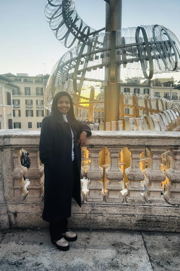 Young woman smiling at camera in front of statue