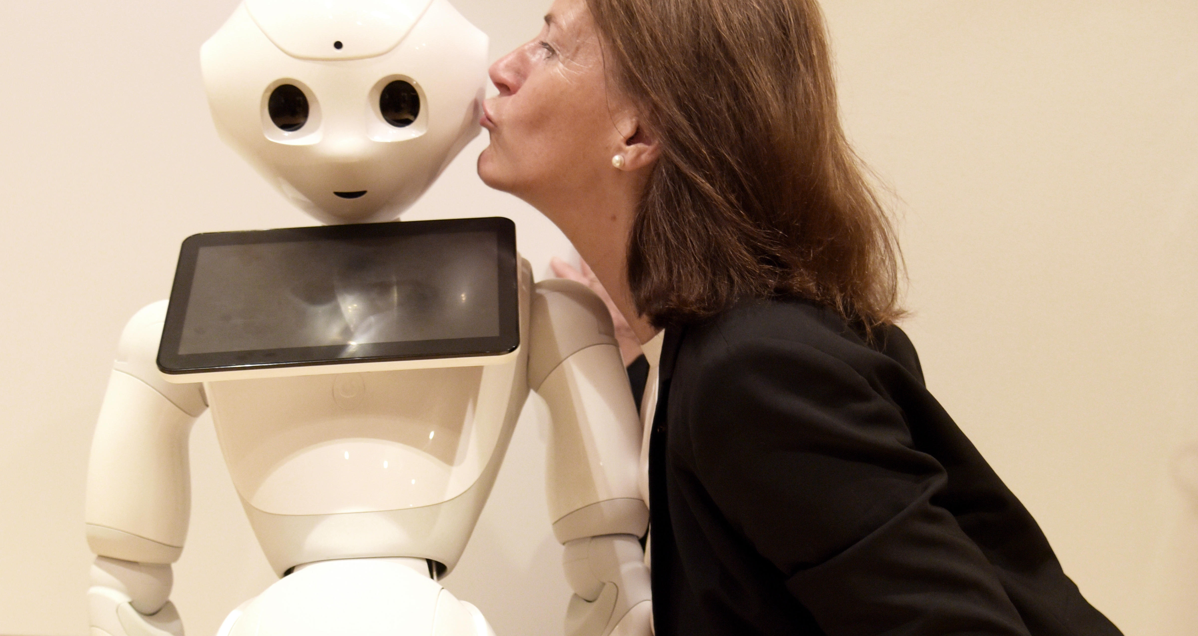 Bettina Husebø kysser roboten Pepper på kinnet.