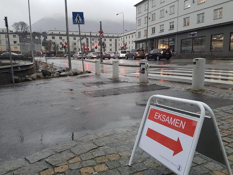 Bilde fra utemiljø utenfor nytt eksamenslokale på Danmarksplass, med skilt med teksten EKSAMEN i rødt.