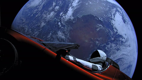 Elon Musk's Tesla Roadster, with Earth in background. "Spaceman" mannequin wearing SpaceX Spacesuit in driving seat