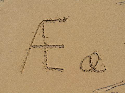 bokstaven Æ, liten og stor, skriven i sand