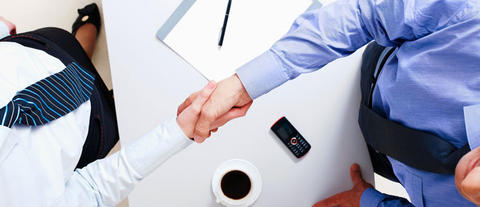 2 business people shaking hands over a contract
