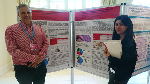 Andrey and Gayanna standing in front of their posters.