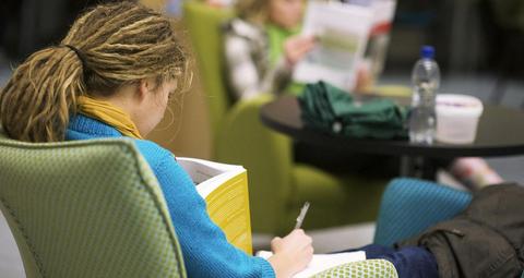 A student reads a book in the library