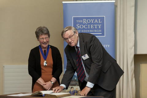 Jocelyn Bell Burnell invites John Birks to sign the Fellows book of the Royal Society of Edinburgh