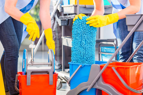 Showing cleaners at work, preparing to clean floors, used to accompany article about how many cleaners suffer bad health unless preventive measures are taken.