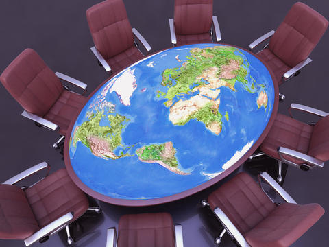 Stock photo of conference table of the world surrounded by chairs.