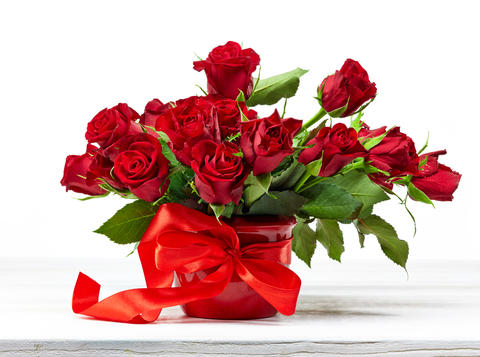 Røde roser i vase med rød sløyfe