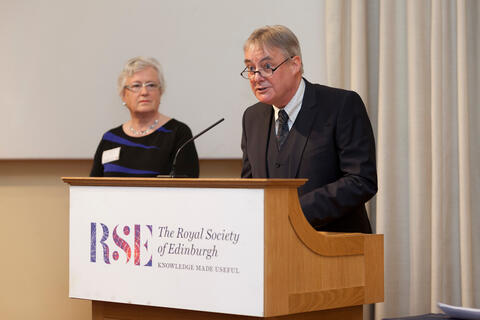 Hilary Birks (left) listening to Des Thompson (right) reading his citation about her