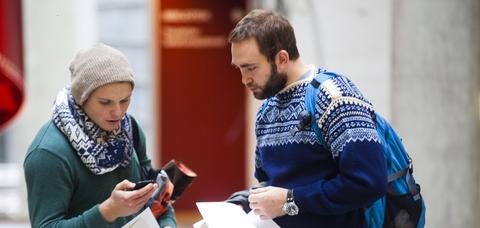 To mannlige studenter ser på en mobil