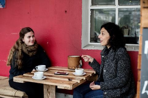 Two female students drinking coffee at a café
