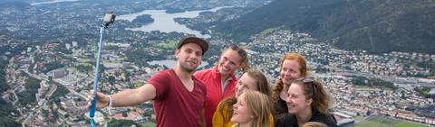 Students hiking taking a selfie with the city in the background