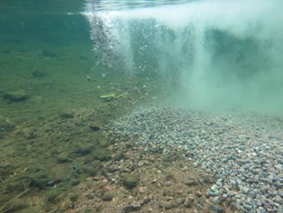 An underwater shot of gravel being added to a river bed