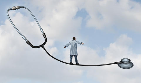doctor balancing on a wire which is a stetoscope, high up in the air.
