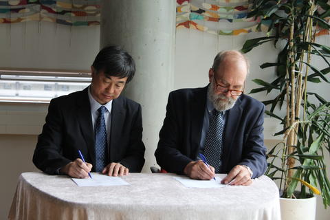President ved Qilu Hospital ved Shandong universitet, Xingang Li, og instituttleder ved Institutt for biomedisin, Rolf Reed, signerer intensjonsavtalen