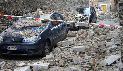 Cars devastated by rubble in one of the streets of the Apennines in Italy after the deadly earthquake of 2009.