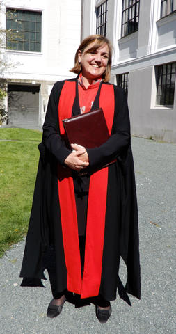 Kathy Willis dressed in her Oxford academic gown standing in the museum garden after receiving her honorary doctorate from University of Bergen