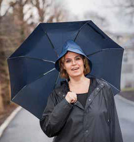 Photo of Line Bjørge in the rain with an umbrella.