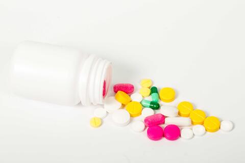 Bottle of medicines, showing the bottle tipped over with pills in various colours. Used to illustrate article about the Centre for Personalized Immunotherapy at University of Bergen.