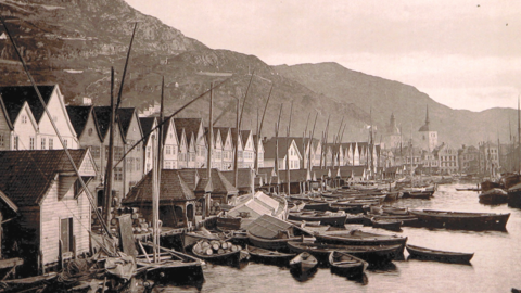 Gamalt frå 1800-talet av Bryggen i Bergen med mange båtar framfor