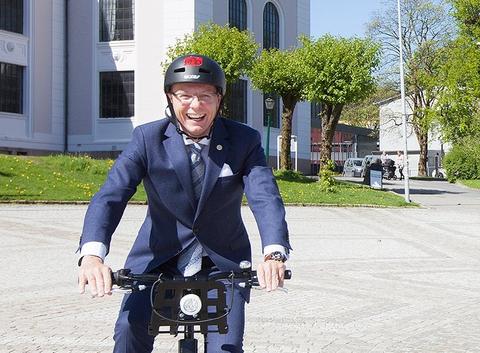 rektor Dag Rune Olsen på sykkel foran museumsbygningen